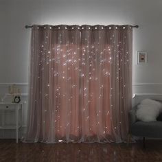 a living room with a couch, chair and curtain in front of a window that has stars on it