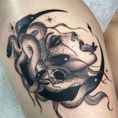 a woman's thigh with a black and white tattoo design on her leg,