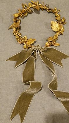 a gold necklace with leaves and ribbons on it