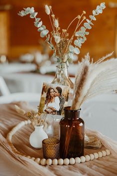 a table topped with vases filled with flowers and pictures