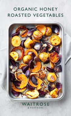 an overhead view of roasted vegetables in a baking dish with the title organic honey roasted vegetables