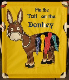 a yellow sign that says pin the tail or the donkey on it's side