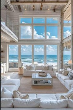 a living room filled with lots of white furniture next to an ocean front view window