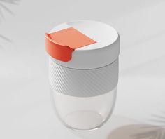 a white cup with an orange lid on it