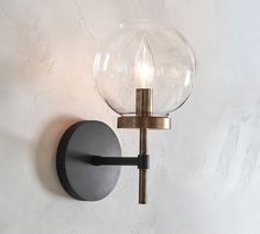 a light that is on the wall next to a white wall with a glass ball