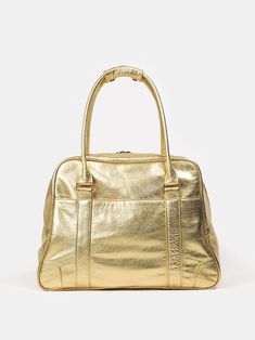 lined weekend tote in metallic gold leather. designed with two fastened interior pockets and two open exterior pockets for smart packing. features brass-toned hardware, double zip closure and two top handles. logo subtly embossed on exterior. measures 13" high x 17" wide at base, tapers to 14". 26" straps. made in los angeles. erica tanov Smart Packing, Long Weekend Getaways, Leather Weekender, Vanity Bag, Barrel Bag, Essential Bag, Warm Brown, Weekender Tote, Carry On Luggage