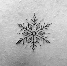 a snowflake tattoo is shown on the back of a woman's stomach