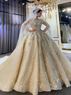 a woman is standing in front of dresses on display at a bridal shop wearing a long sleeved wedding dress