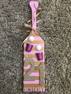 a pink and gold door hanger with cupcakes on the number twenty two