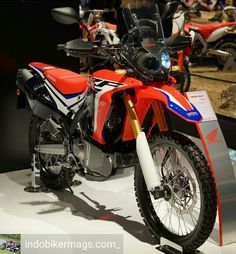 an orange and blue motorcycle on display in a showroom