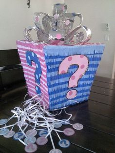 a blue and pink gift box with question mark on it sitting on top of a table