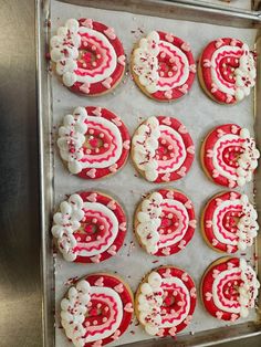 red and white decorated cookies sitting on top of a cookie sheet