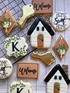 decorated cookies are arranged on a wire rack with welcome home signs and dog houses in the background