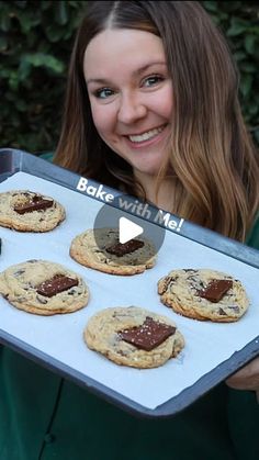 a woman holding a tray with cookies and jams on it that says bake with me