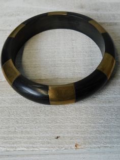 "Vintage Black Horn and Brass Bangle Bracelet. unmarked. ca 1970s-1980s. It is 2- 1/2\" across the opening and 5/8\" W. Normal wear but no damage found. Great condition." Vintage Black Cuff Bracelet As Gift, Vintage Black Bangle Cuff Bracelet, Vintage Black Bangle As Gift, Vintage Black Bangle, Brass Bangle, Black And Tan, Bangle Bracelet, Horn, Vintage Black