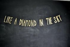 the words like a diamond in the sky are written on a blackboard with gold foil