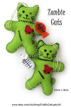 two green stuffed cats are hanging on a string