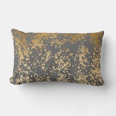 a gray and gold pillow sitting on top of a white wall