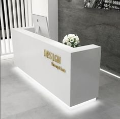 a white reception desk with flowers in it