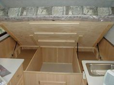 the inside of a small kitchen with sink, stove and dishwasher in it