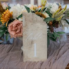 a table with flowers and a sign that says it is 1 on the table number