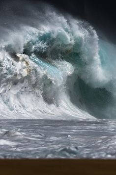 a large wave crashing over the top of a beach