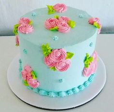 a blue cake with pink flowers on it