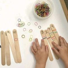 two children are playing with wooden pegs and colored rings on the table next to each other