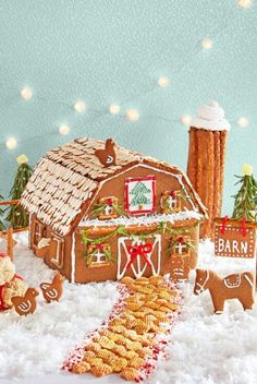 a gingerbread house with christmas decorations and cookies in the foreground, on a snowy surface