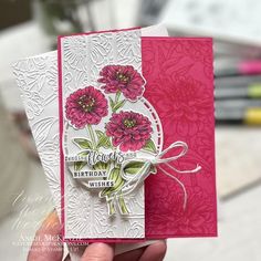 a person holding up a card with flowers on it