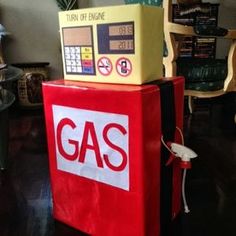 a red and yellow gas station box sitting on top of a chair in a living room