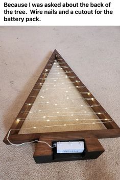 an upside down wooden shelf with lights on the bottom and below it is a battery pack