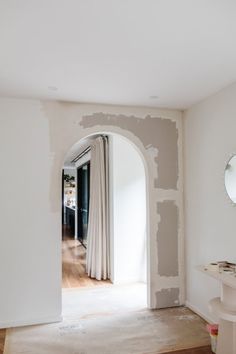 an archway leading into a bedroom with white walls