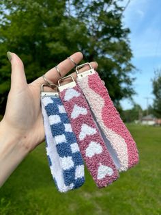 three different colored wristbands are held up in the air by someone's hand