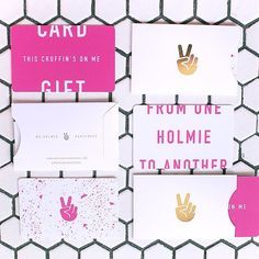 some pink and gold greeting cards on a white netted wall with the words, mommeshakhouse