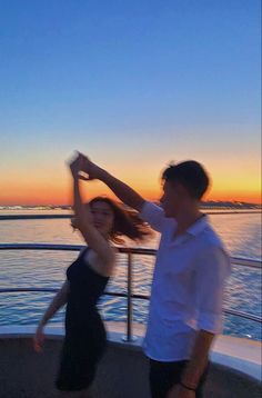 two people dancing on a boat at sunset