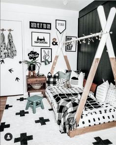 a bedroom with black and white decor on the walls, bedding and rugs