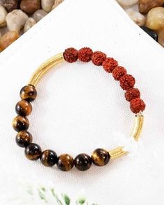 This simple yet powerful wrist mala features matched 8mm Rudraksha and tiger eye beads, framed by our signature gold vermeil cylindrical spacers. This divine combination of power beads helps us recognize the opportunities we are given, and enables us to act upon them with clarity and strength, while helping channelize the negative energy away from our paths. Activated Rudraksha Beads Tiger Eye: Endurance, Perseverance, Grounding Gold: Abundance, Willpower and Strength Choose your size 6"- 7" or Rudraksha Gold Bracelet For Men, Rudraksha Beads, Wrist Mala, Tiger Eye Beads, Eye Beads, Tigers Eye, Negative Energy, Tiger Eye, Gold Vermeil