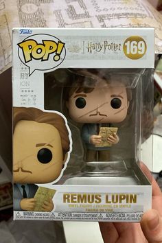 a person holding up a harry potter figurine in a box with the words, remus lupin on it