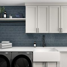 a washer and dryer in a kitchen with blue backsplash tiles on the wall