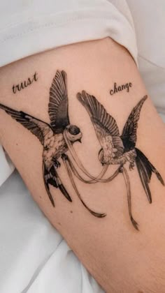 two birds flying next to each other with the words trust and change tattooed on them