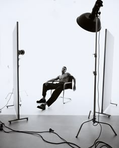 a man sitting in a chair next to three lights