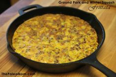 a skillet filled with food sitting on top of a wooden table