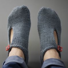 a person's feet wearing slippers with red buttons on the bottom and toes