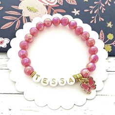 "Custom Name Bracelet, Butterfly Charm Jewelry for Girls, Stretchy Beaded Bracelet, Kids Gift, Children's Jewelry ----- This richly colored hot pink beaded stretch name bracelet features a cute enamel butterfly with fine detail.     Gold and white letters showcase the little girl's name.   INCLUDES: 🌸 One hot pink beaded butterfly name bracelet SIZE & MATERIALS: 🌸 6\" is shipped; if you want different size, please leave me a note in the \"notes to seller\" at checkout  🌸 8mm acrylic pearlesce Youre The Bomb, Bracelet Butterfly, Graduation Keychain, Beaded Butterfly, Children's Jewelry, Enamel Butterfly, Stretchy Beaded Bracelet, Jewelry For Girls, Childrens Jewelry