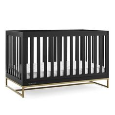 a black crib with white sheets on the bottom, and gold trimmings