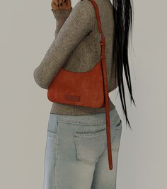 a woman with long black hair is holding a cell phone in her right hand and wearing a brown purse