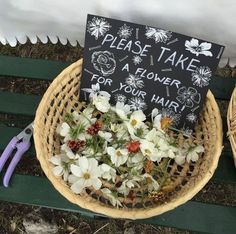 flowers in a basket with a sign that says please take a flower for your hair