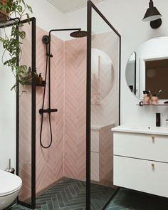 a bathroom with a shower, sink and potted plant on the counter in front of it