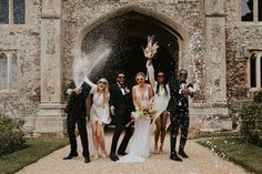 a group of people standing next to each other in front of a building with confetti